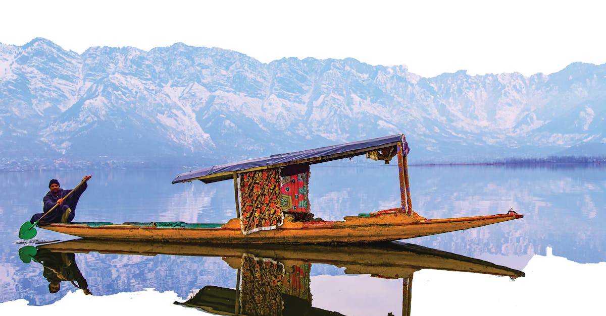A vibrant shikara on Dal Lake with the stunning Himalayan backdrop, perfect for travel exploration. 🧭 भारत में घूमने की जगहें: हर सफर एक नई कहानी