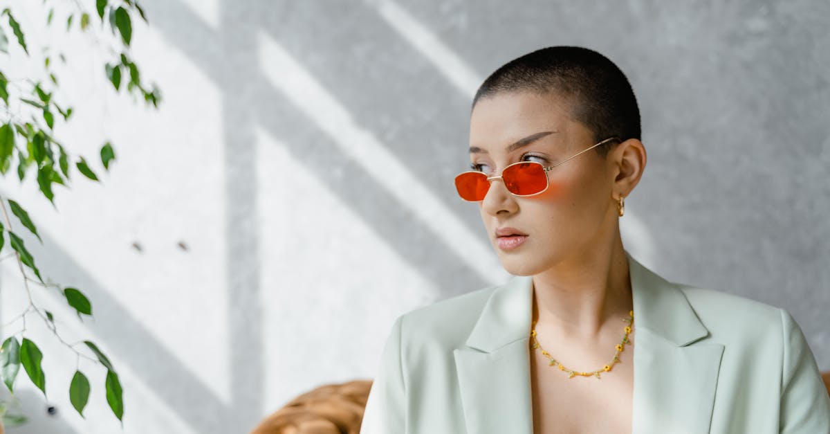 How to improve self esteem Confident woman wearing red sunglasses and a blazer, exuding modern elegance.
