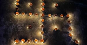 A high angle view of candles arranged to form a religious swastika symbol at night. वास्तु दोष हटाने के लिए 25 महा-उपाय: घर में सुख, समृद्धि और शांति का प्रवेश
