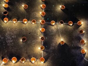 A high angle view of candles arranged to form a religious swastika symbol at night. वास्तु दोष हटाने के लिए 25 महा-उपाय: घर में सुख, समृद्धि और शांति का प्रवेश