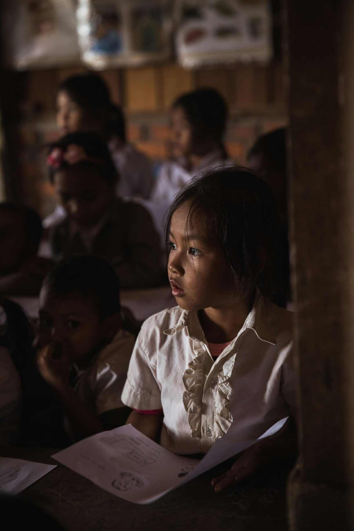Focused children in a dimly lit classroom attentively listening and studying. शिक्षा और छात्र भविष्यफल 2026: क्या इस साल मिलेगी आपको मनचाही सफलता?