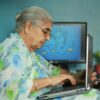 Elderly Indian woman in floral saree using a laptop at home. 2026 में महिलाओं के लिए सर्वश्रेष्ठ वर्क-फ्रॉम-होम बिजनेस आइडियाज: घर से सफलता का सफर