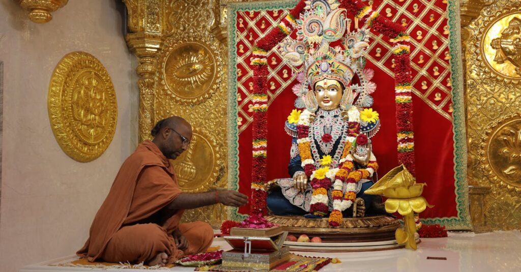 A monk engaged in a ritual at the ornate Swaminarayan Mandir in Poicha, Gujarat, India.