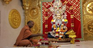 A monk engaged in a ritual at the ornate Swaminarayan Mandir in Poicha, Gujarat, India.