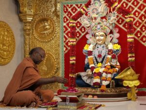 A monk engaged in a ritual at the ornate Swaminarayan Mandir in Poicha, Gujarat, India.