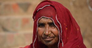 A dignified portrait of an Indian woman in a red saree with intricate embroidery, showcasing cultural heritage. माघ मेला 2026: केवल आस्था नहीं, एक 'अदृश्य' नगर का विज्ञान और अनसुने रहस्य
