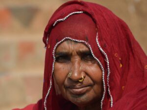 A dignified portrait of an Indian woman in a red saree with intricate embroidery, showcasing cultural heritage. माघ मेला 2026: केवल आस्था नहीं, एक 'अदृश्य' नगर का विज्ञान और अनसुने रहस्य